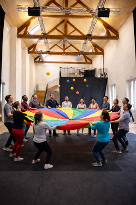 activite-de-groupe-avec-parachute-colore Activité de groupe avec parachute coloré